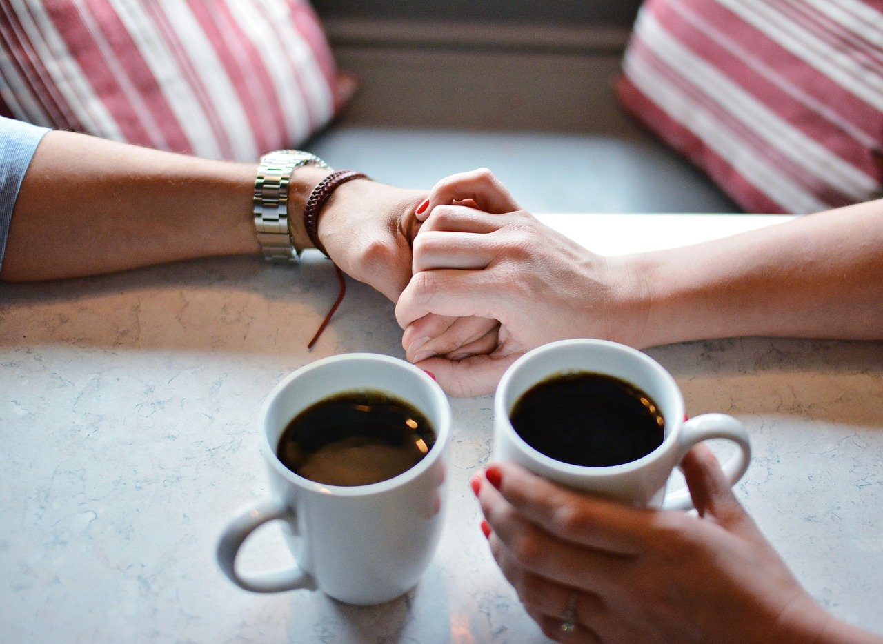 two hands holding over a coffees